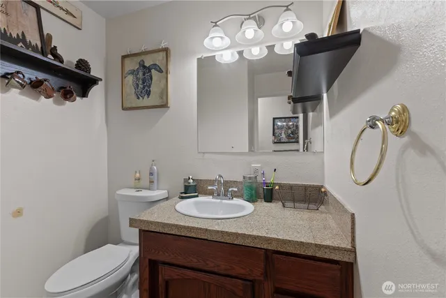 a bathroom with a granite countertop sink a toilet and a mirror