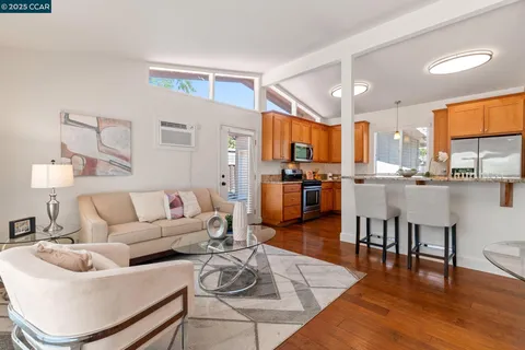 a living room with furniture kitchen and a wooden floor