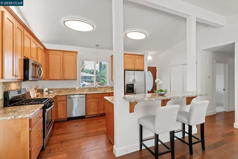 a kitchen with a table chairs stove and cabinets