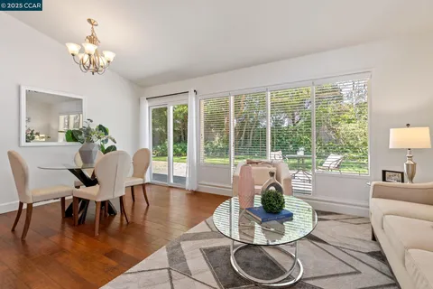a dining room with furniture a large window and a potted plant