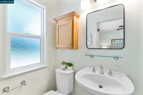 a bathroom with a toilet a sink and mirror
