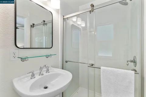 a bathroom with a sink a glass door and shower