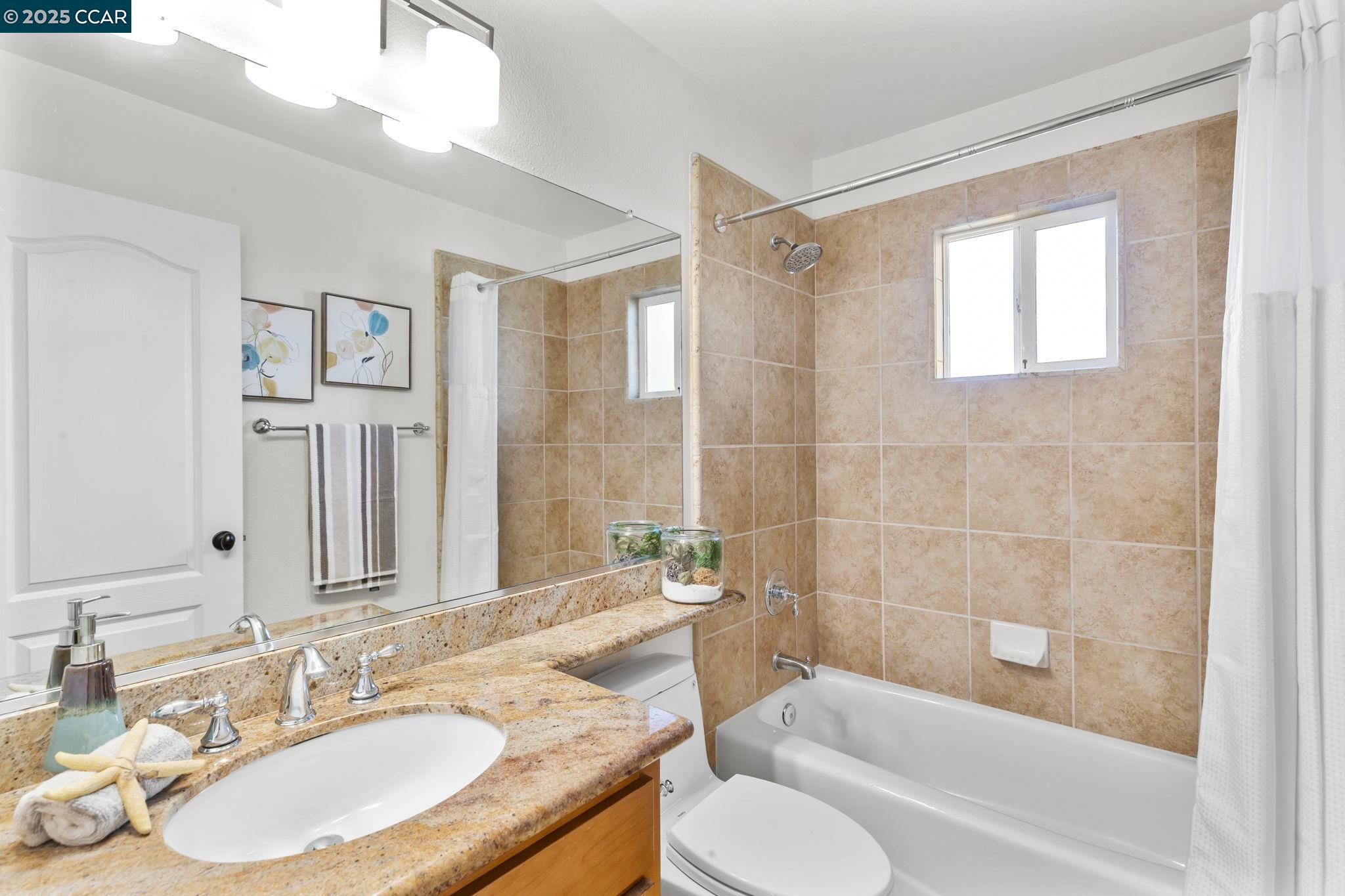 3249 Claudia Drive Concord, CA 94519 - Photo 29 of 34 a bathroom with a granite countertop sink toilet a large mirror a bathtub and shower