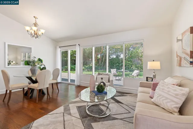 a living room with furniture a table and a large window