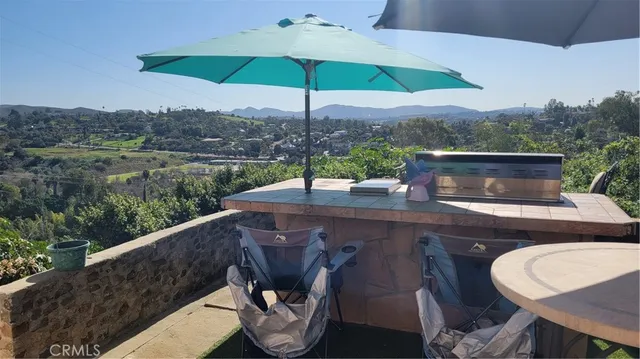 a view of a table and chairs under an umbrella