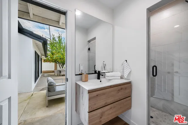 a bathroom with a sink a mirror and shower