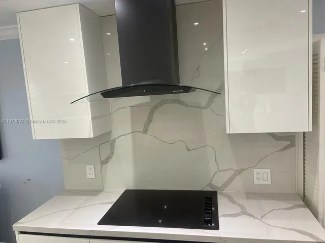 a living room with stainless steel appliances furniture a rug and a kitchen counter top