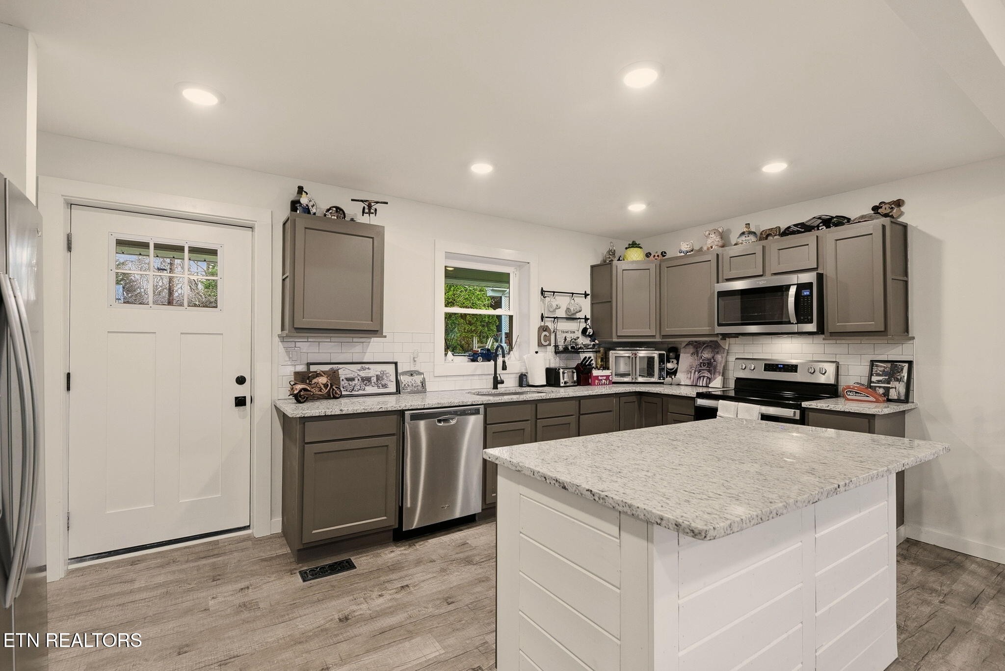 110 Parma Road Oak Ridge, TN 37830 - Photo 6 of 23 a kitchen with stainless steel appliances a stove top oven a sink a refrigerator white cabinets and wooden floor