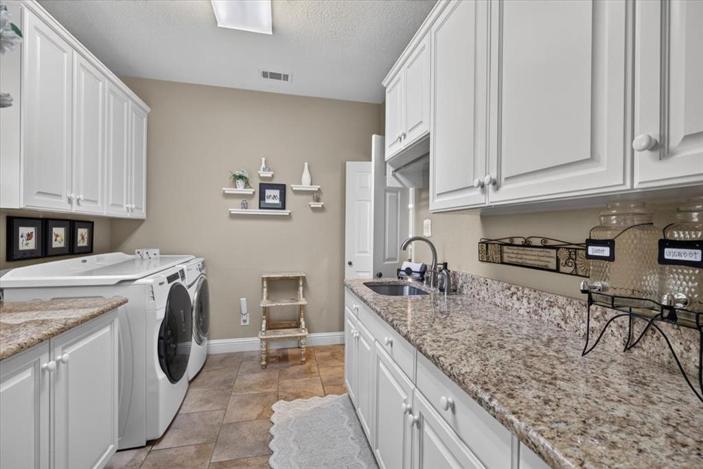 111 Trailwood Road Enchanted Oaks, TX 75156 - Photo 22 of 33 a kitchen with granite countertop a sink a stove and cabinets