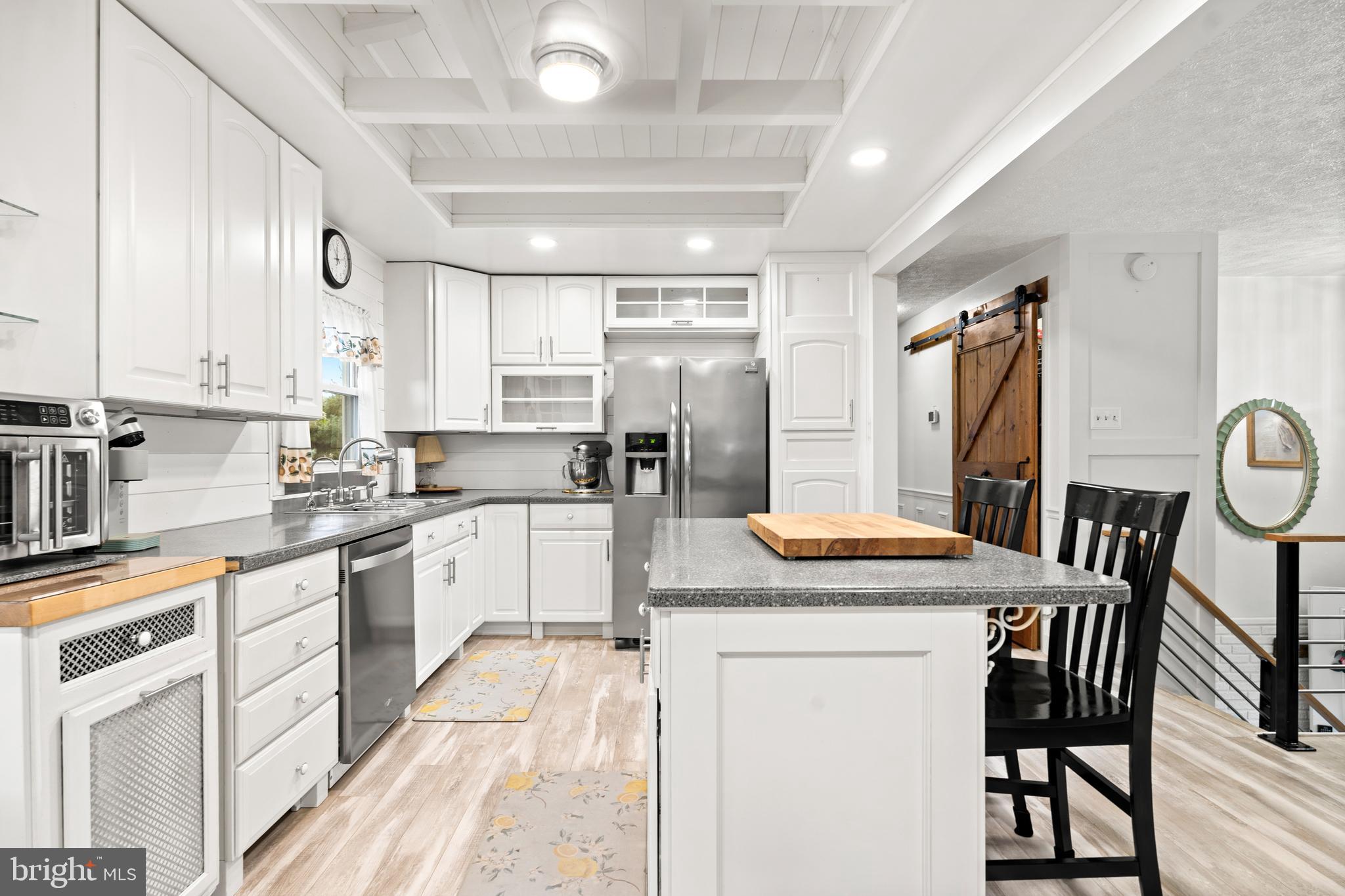 7907 Stone Hearth Road Severn, MD 21144 - Photo 12 of 24 a kitchen with stainless steel appliances granite countertop a stove a sink dishwasher a refrigerator with white cabinets and wooden floor