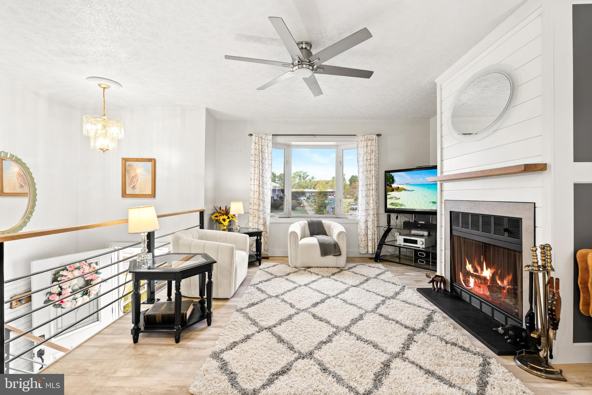 7907 Stone Hearth Road Severn, MD 21144 - Photo 8 of 24 a living room with furniture a fireplace and a chandelier