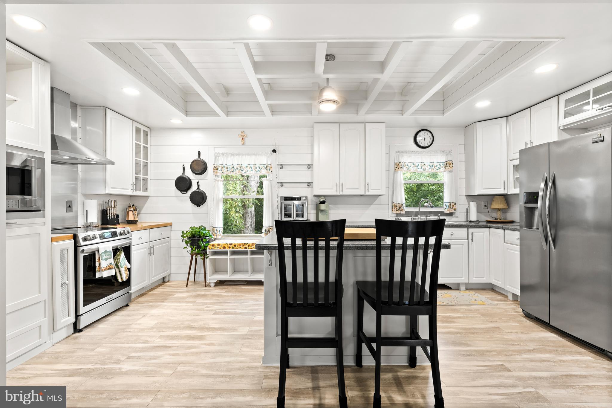 7907 Stone Hearth Road Severn, MD 21144 - Photo 10 of 24 a kitchen with stainless steel appliances granite countertop a dining table chairs refrigerator sink and cabinets