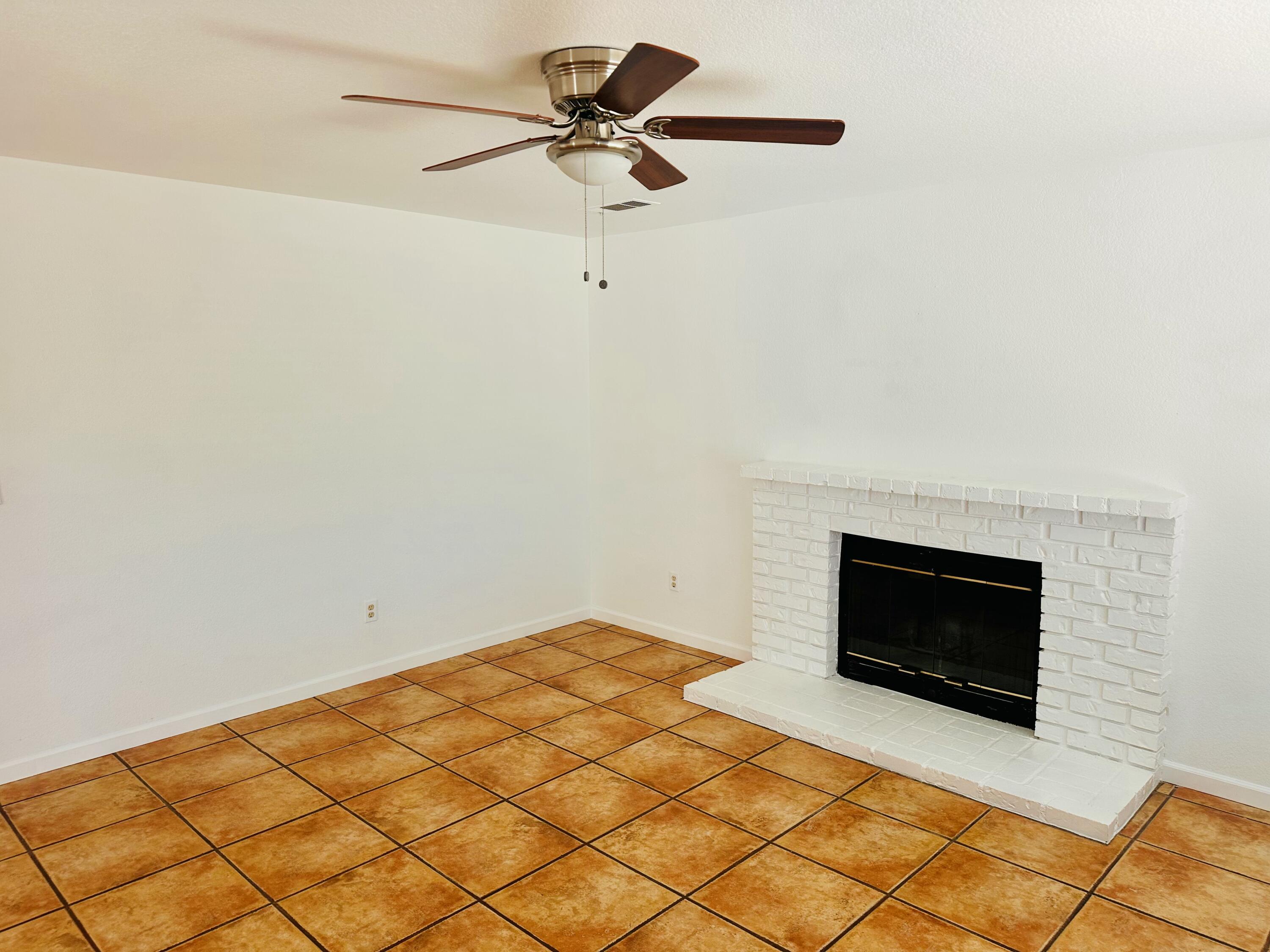 30880 Farr Road Visalia, CA 93291 - Photo 6 of 27 a room with a fireplace and a ceiling fan