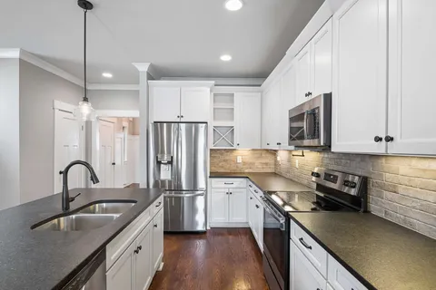 a kitchen with stainless steel appliances a sink stove and refrigerator