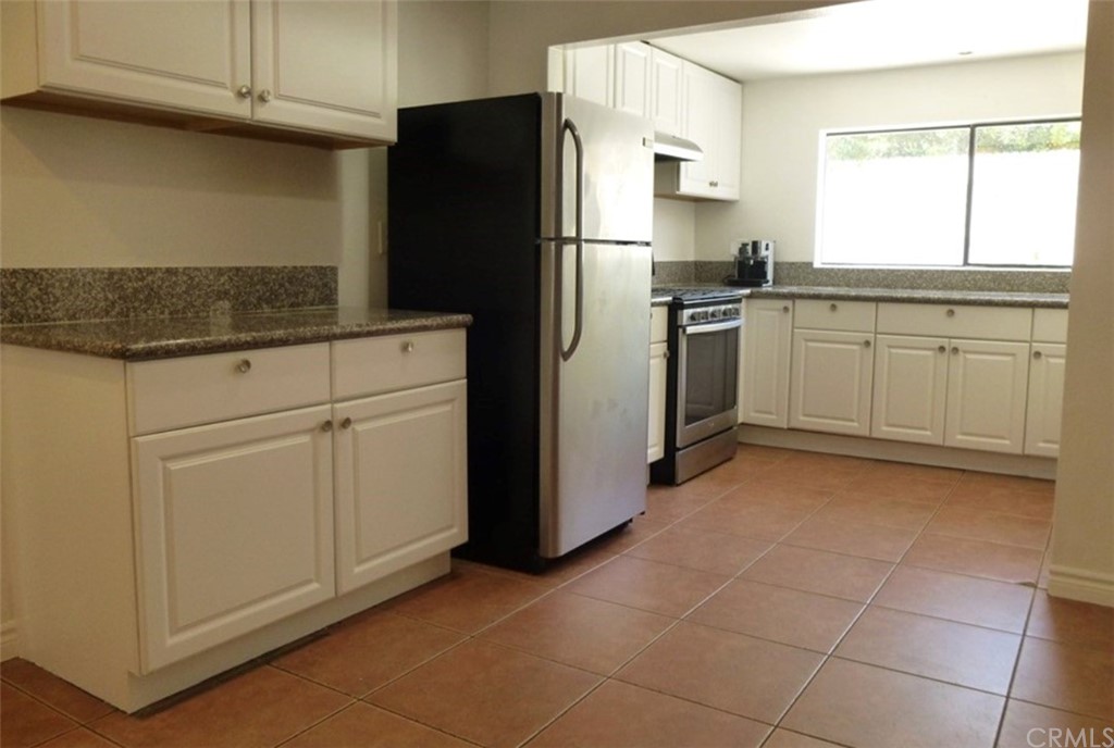 53 Carver Irvine, CA 92620 - Photo 3 of 12 a kitchen with white cabinets and refrigerator