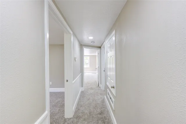 a view of an empty room with a window and closet area