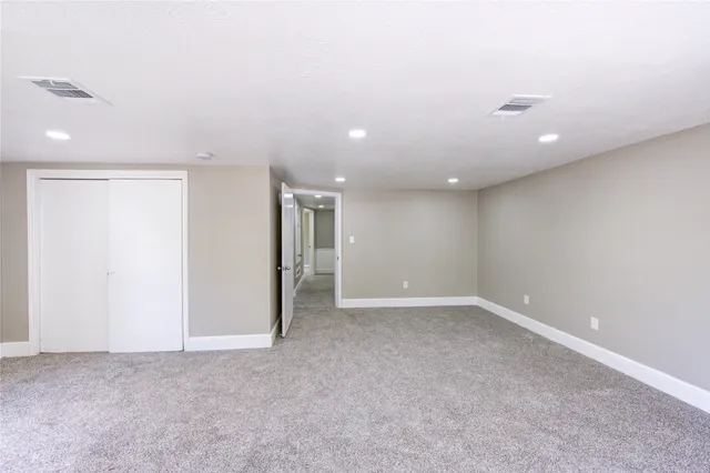 a view of a big room with windows and chandelier fan
