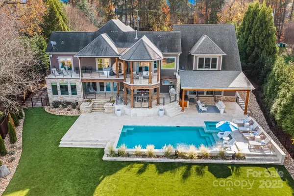 an aerial view of a house with swimming pool and a yard