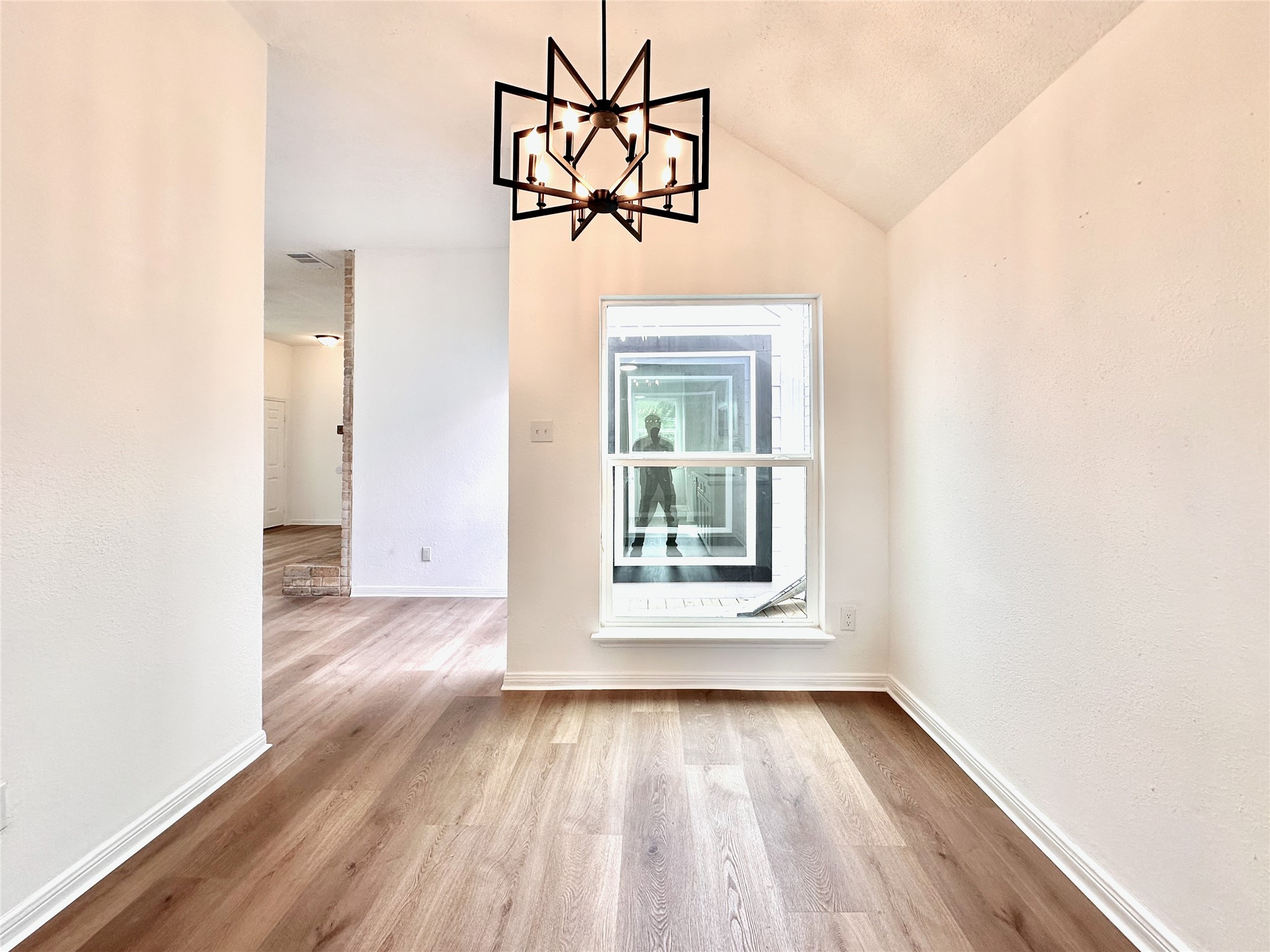 16411 Gold Ridge Lane Houston, TX 77053 - Photo 12 of 25 an empty room with wooden floor chandelier and windows