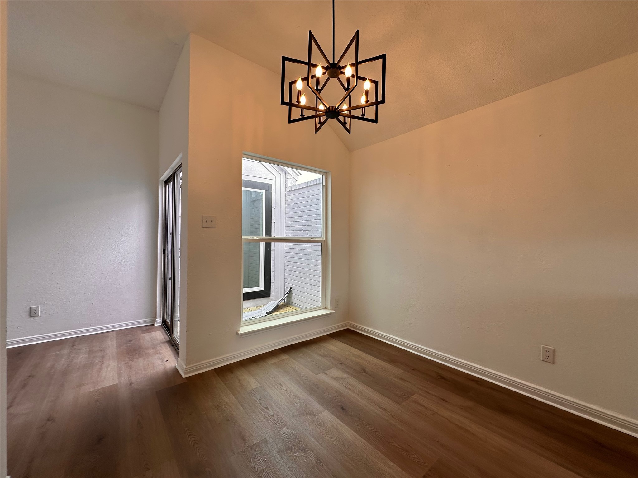 16411 Gold Ridge Lane Houston, TX 77053 - Photo 14 of 25 an empty room with wooden floor chandelier and windows