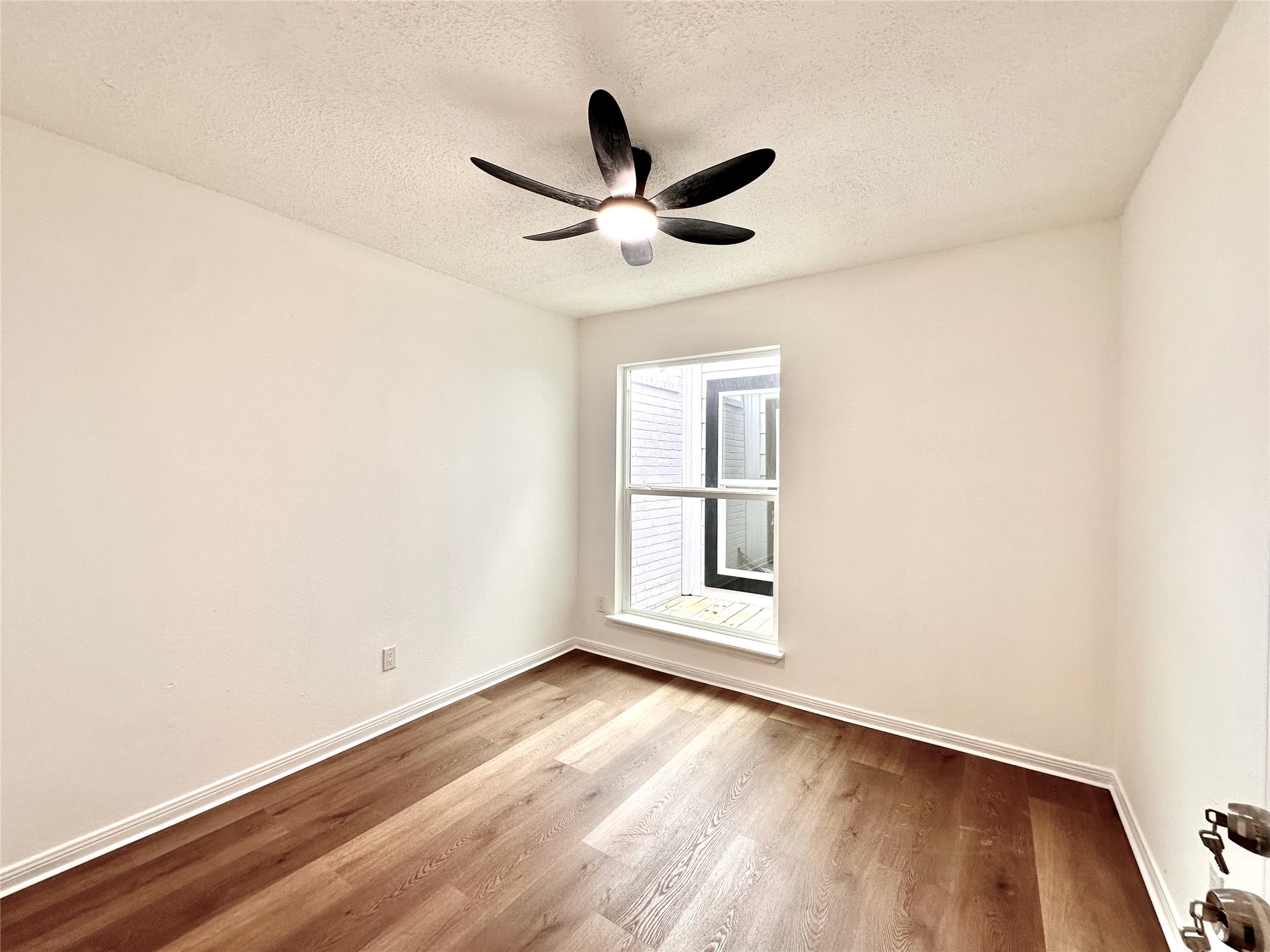 16411 Gold Ridge Lane Houston, TX 77053 - Photo 21 of 25 an empty room with wooden floor ceiling fan and windows