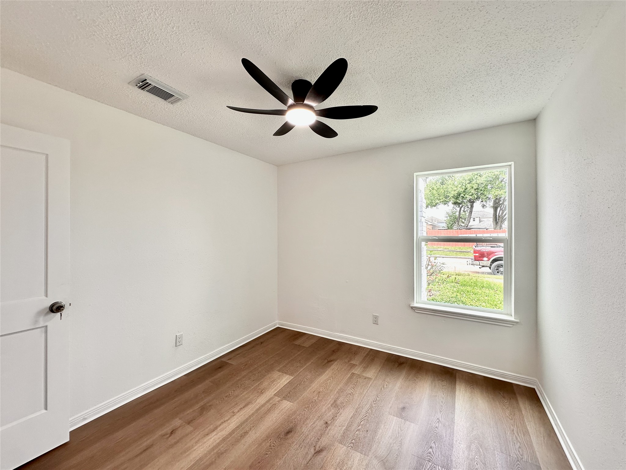 16411 Gold Ridge Lane Houston, TX 77053 - Photo 23 of 25 an empty room with wooden floor ceiling fan and windows