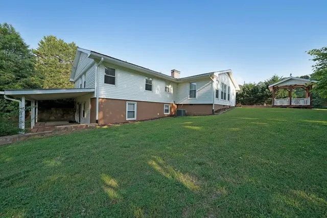 a view of a house with a yard and sitting area