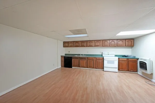 a kitchen with stainless steel appliances wooden cabinets and a wooden floor