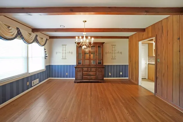 a view of a hallway with wooden floor and stairs