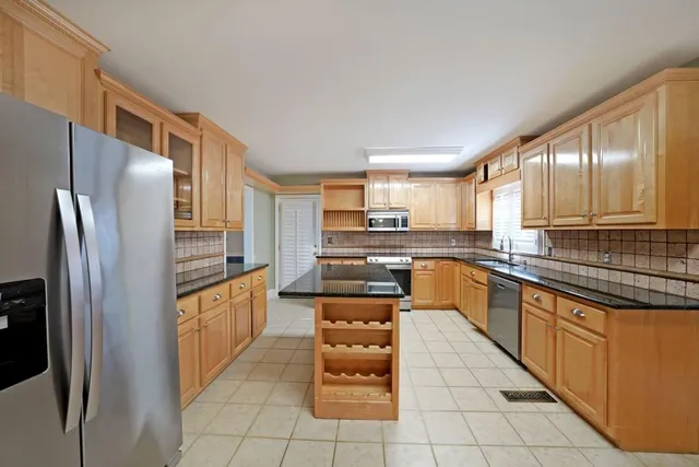 a kitchen with stainless steel appliances granite countertop a refrigerator and a stove top oven