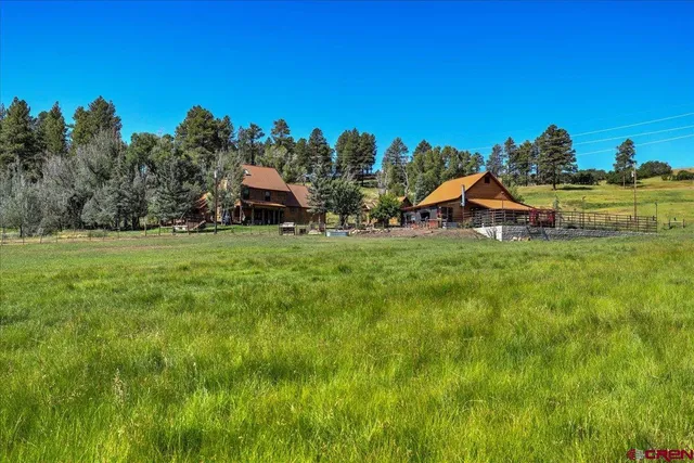 a view of a house with a yard and sitting area