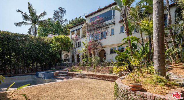 a view of a patio with couches table and chairs and potted plants