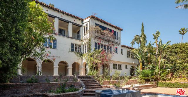 a view of a white house with a yard and sitting area