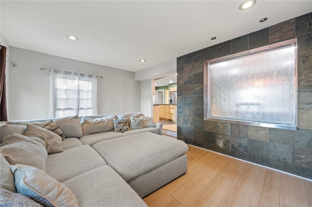 Family room featuring wall water feature and hardwood type