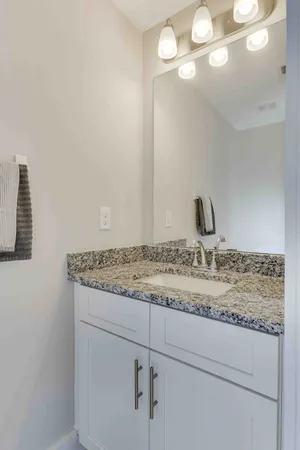 a bathroom with a granite countertop sink and a mirror