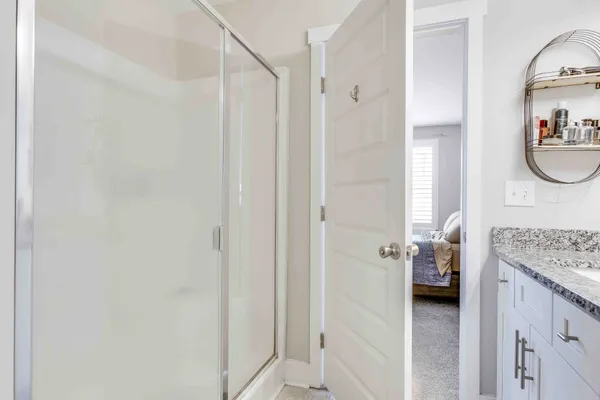 a en suite bathroom with a granite countertop sink and a mirror