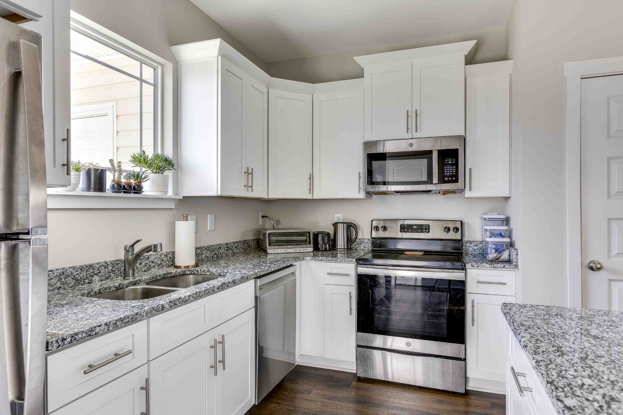 1061 Wells Way Spring Hill, TN 37174 - Photo 10 of 21 a kitchen with granite countertop white cabinets and white stainless steel appliances