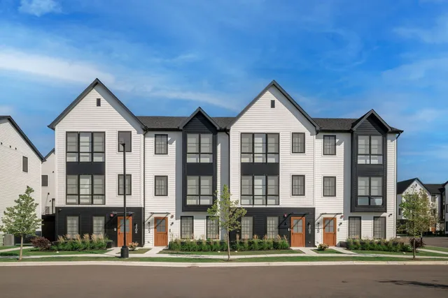 front view of a brick house with a yard