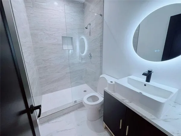 a bathroom with a sink a toilet and shower