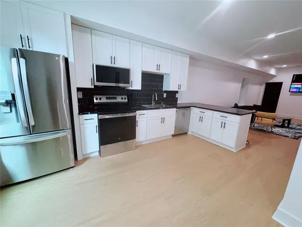 a kitchen with stainless steel appliances a refrigerator sink and white cabinets