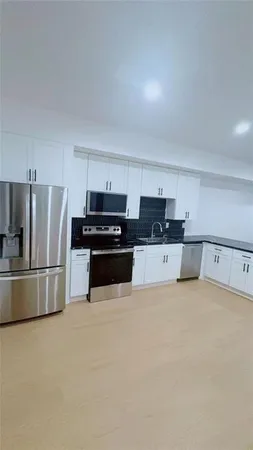 a kitchen with a refrigerator a stove top oven a sink and a window