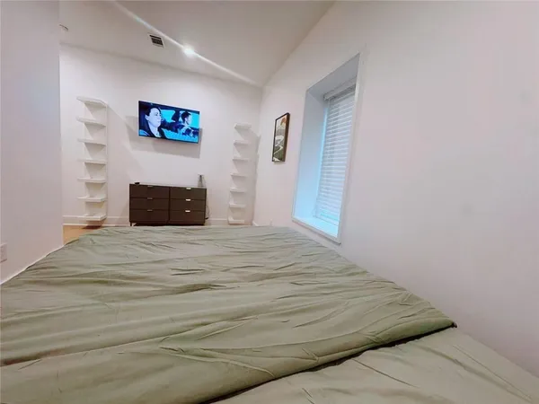 a bed sitting in a bedroom with a mirror