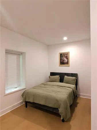 a bed sitting in a bedroom and a mirror