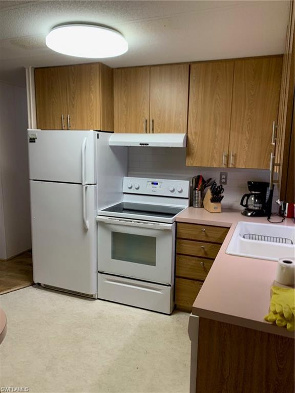 9322 Pitt Road Bonita Springs, FL 34135 - Photo 18 of 24 a kitchen with a stove a sink and a refrigerator