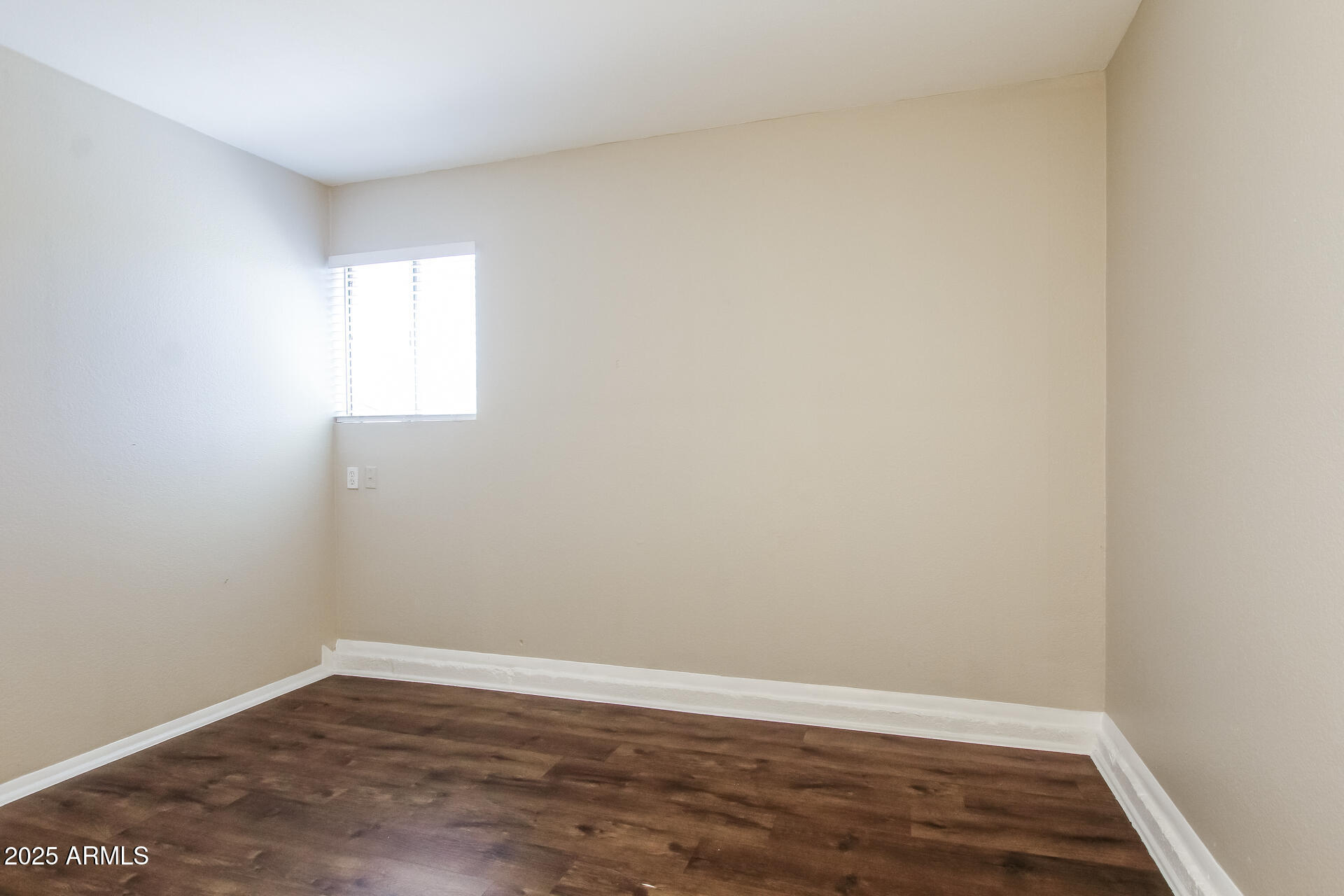 7130 West Merrell Street Phoenix, AZ 85033 - Photo 15 of 21 a view of an empty room with wooden floor and a window