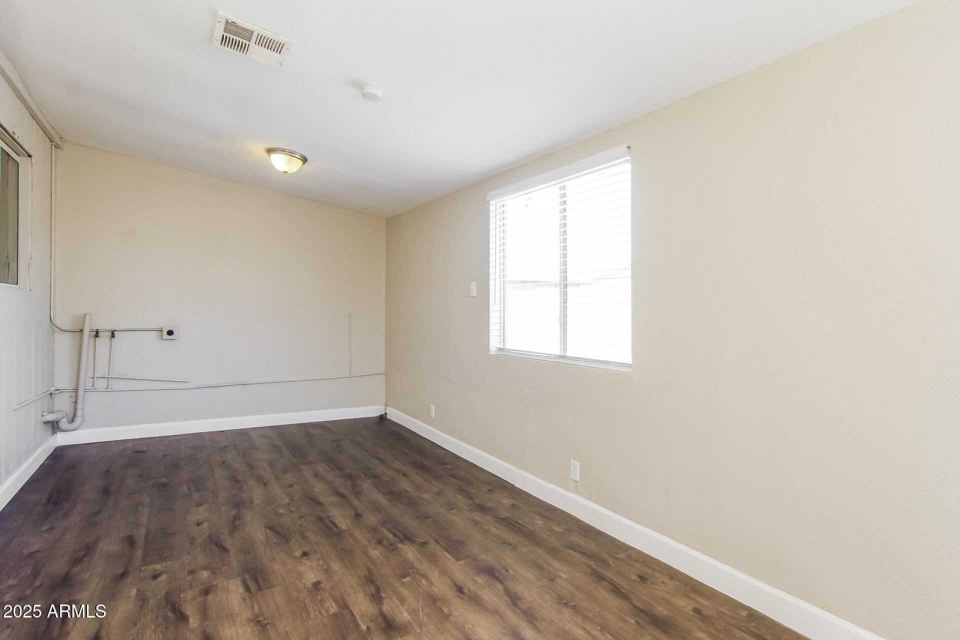 7130 West Merrell Street Phoenix, AZ 85033 - Photo 18 of 21 an empty room with wooden floor and windows