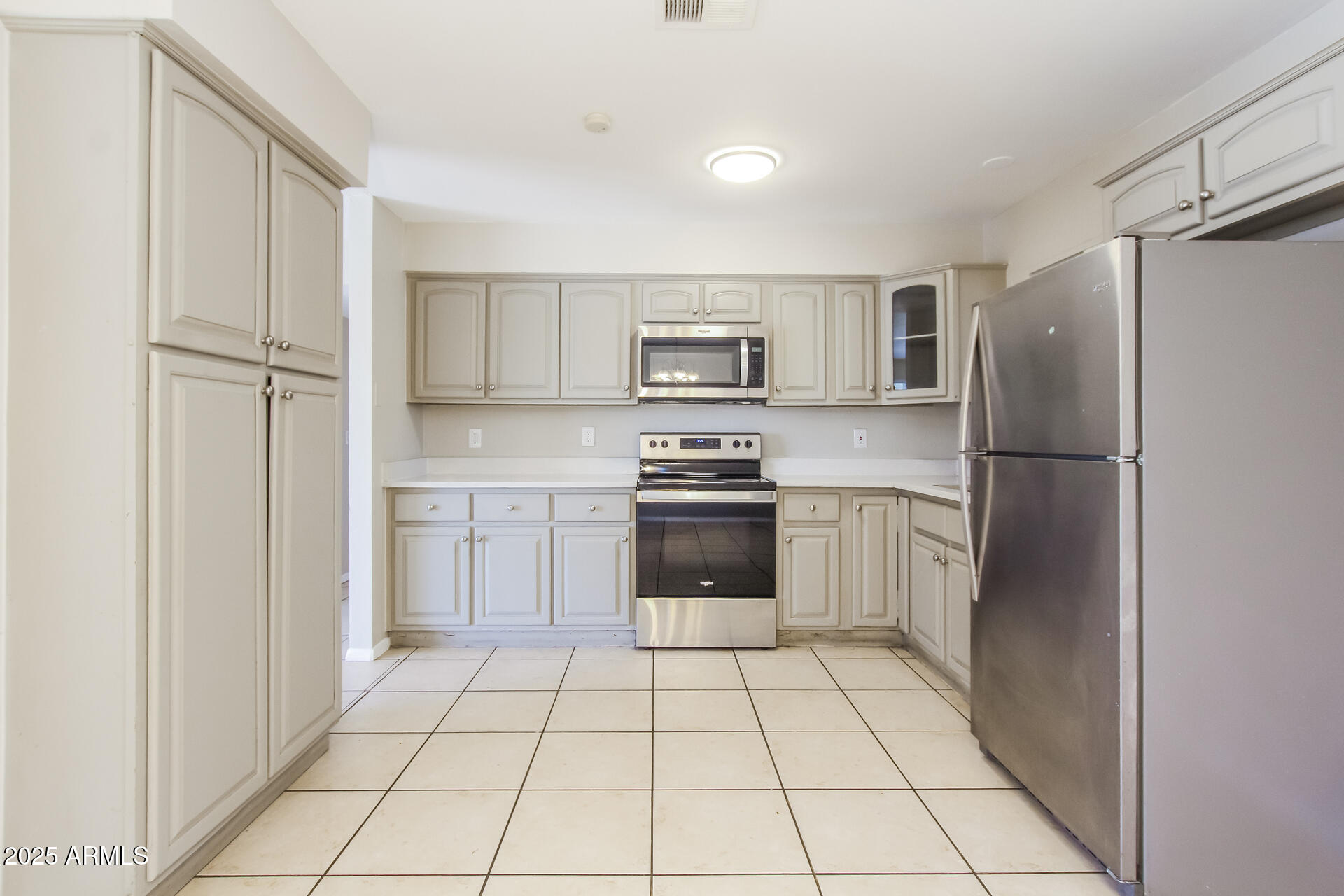 7130 West Merrell Street Phoenix, AZ 85033 - Photo 6 of 21 a kitchen with a refrigerator sink and cabinets