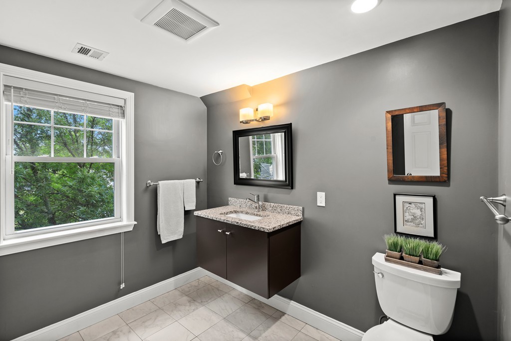 36 River Street, Unit 2 Arlington, MA 02474 - Photo 19 of 32 a bathroom with a granite countertop sink toilet and mirror