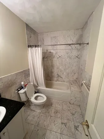 a bath room with a toilet and a shower