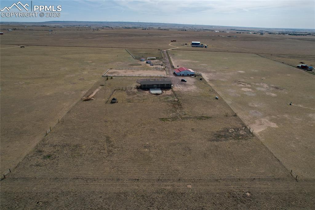 7880 J D Johnson Road Peyton, CO 80831 - Photo 24 of 50 Aerial perspective showcasing a sprawling property with multiple structures